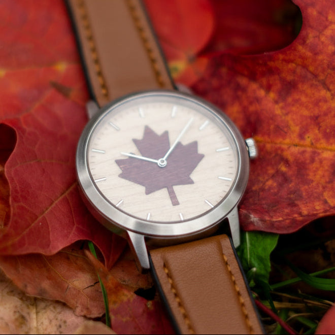 Watch with a maple leaf design on a bed of autumn leaves